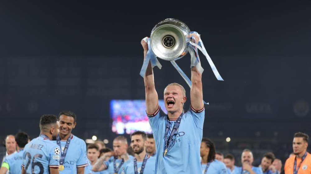 Erling Haaland holding the Champions League trophy, showcasing his remarkable records and achievements